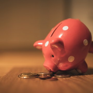 piggy bank with coins around it